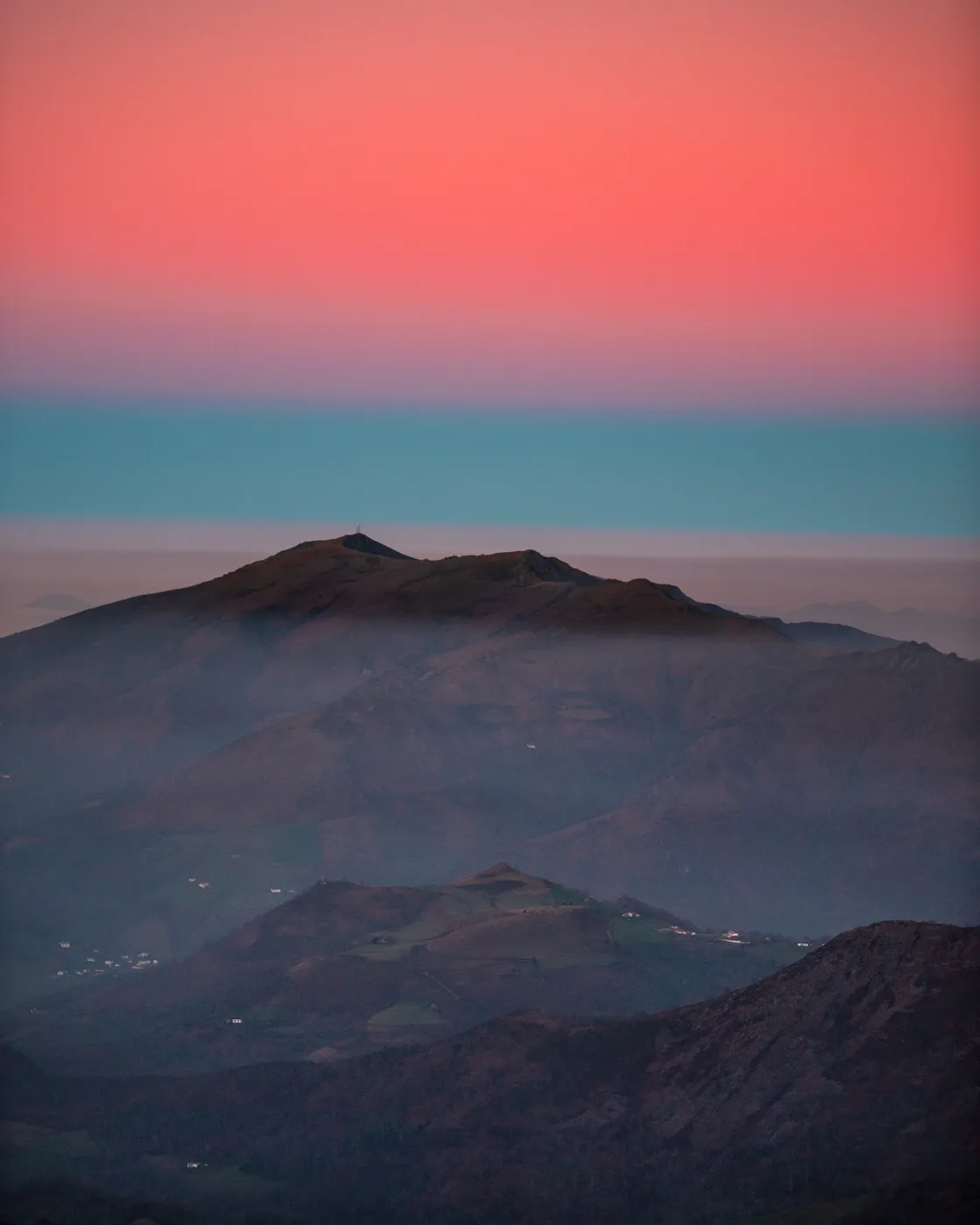 L'Artzamendi émergeant de la brume sous un ciel rose et bleu, vu depuis la crête d'Iparla