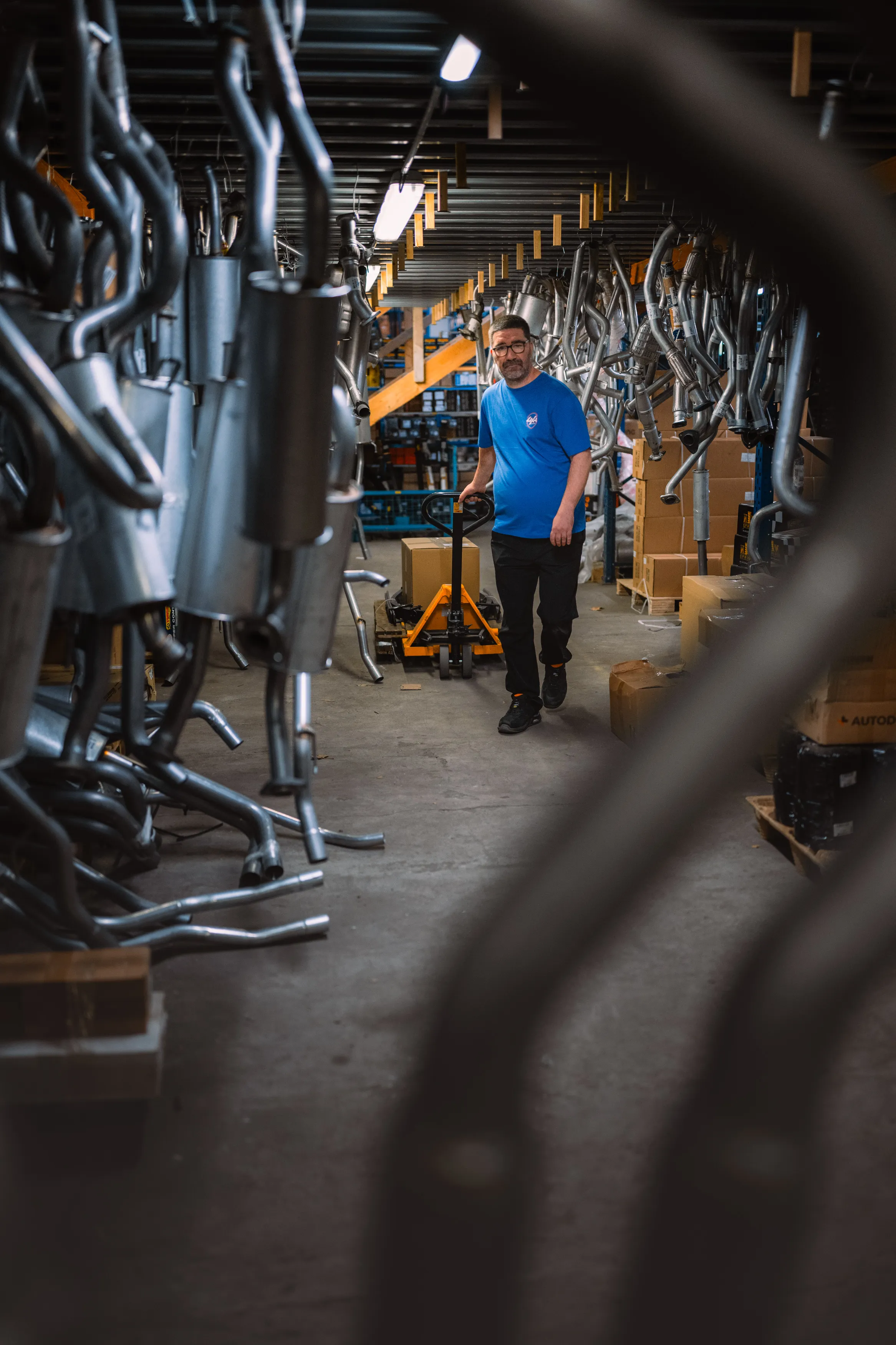 Préparateur de commandes dans l'allée des lignes d'échappement de l'entrepôt Euro4x4Parts