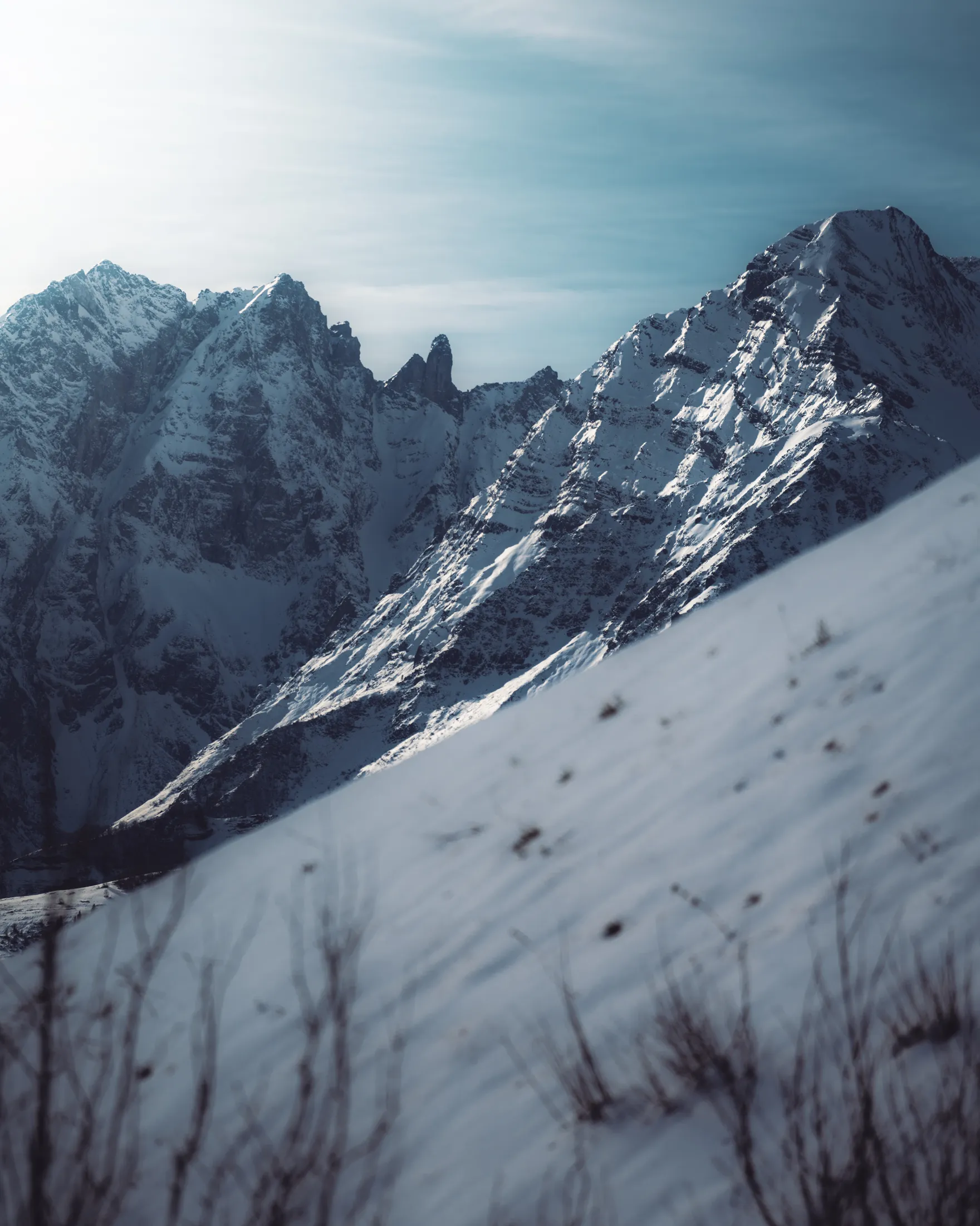 Des arêtes enneigées éclairées par le soleil rasant au-dessus d'une pente de neige, à Lauriolle
