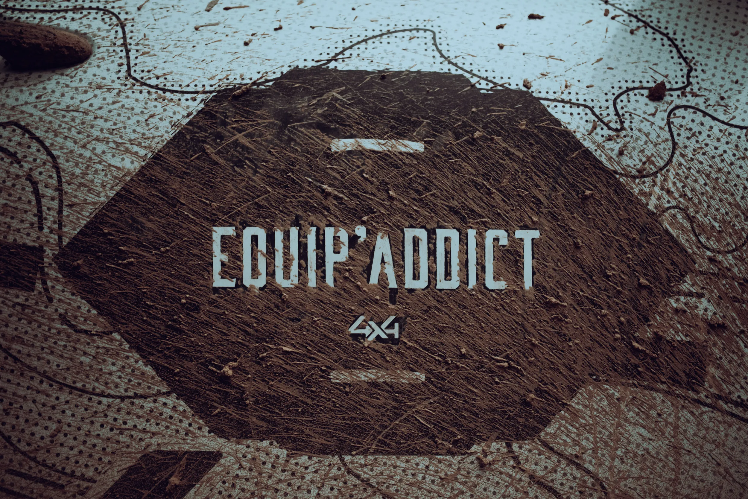 Logo Equip'Addict 4x4, la marque de tentes et d'équipement de bivouac d'Euro4x4Parts, sur une bâche maculée de boue