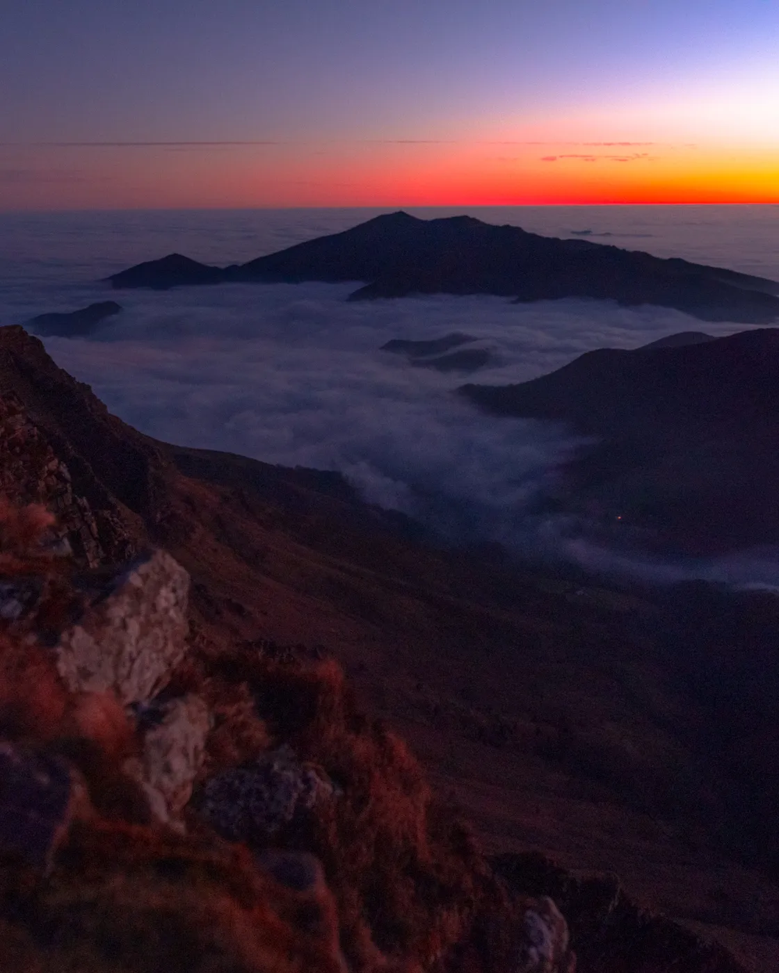 Mer de nuages au crépuscule vue depuis la crête d'Iparla, les sommets émergeant comme des îles
