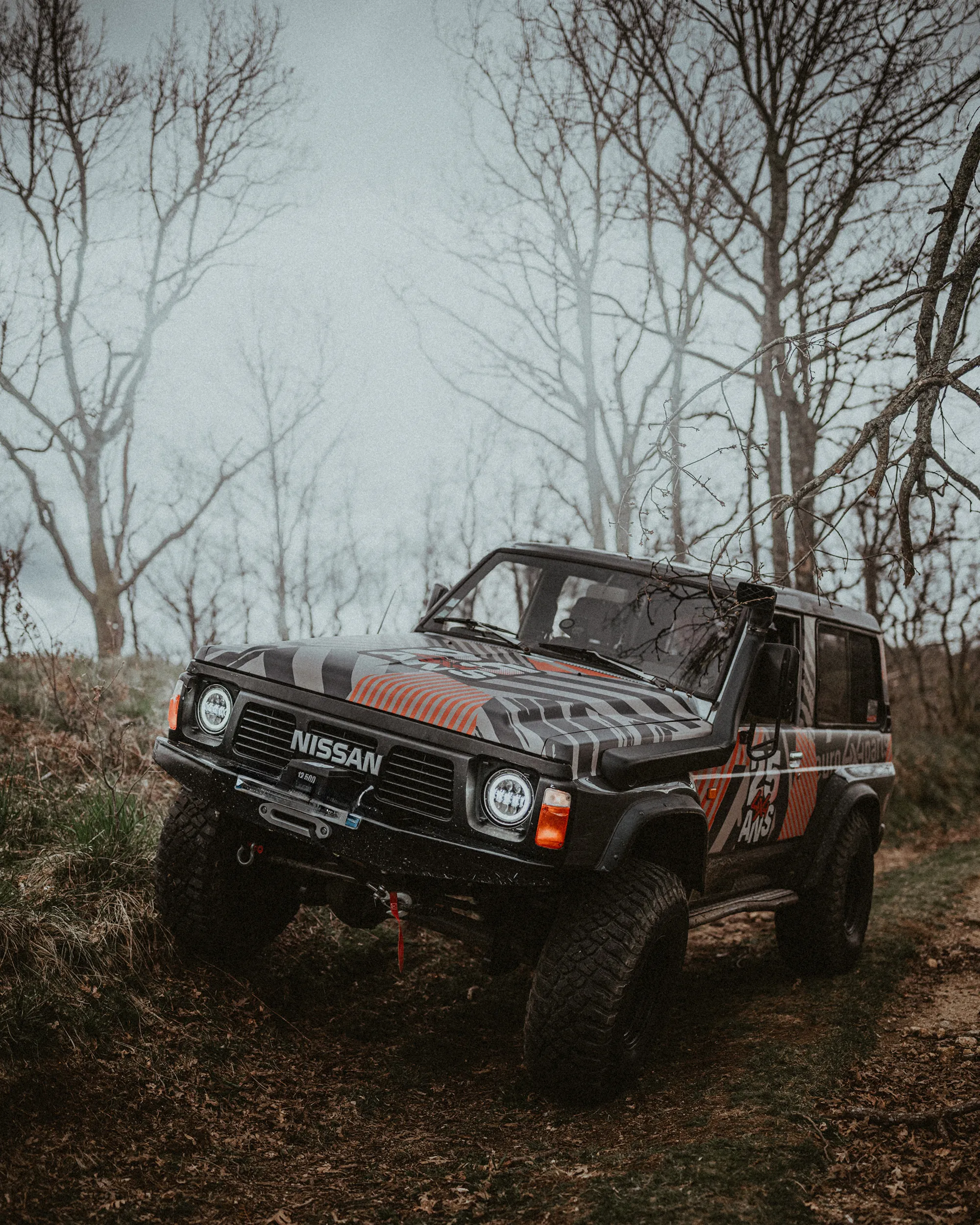 Nissan Patrol dans une forêt d'arbres nus noyée de brume