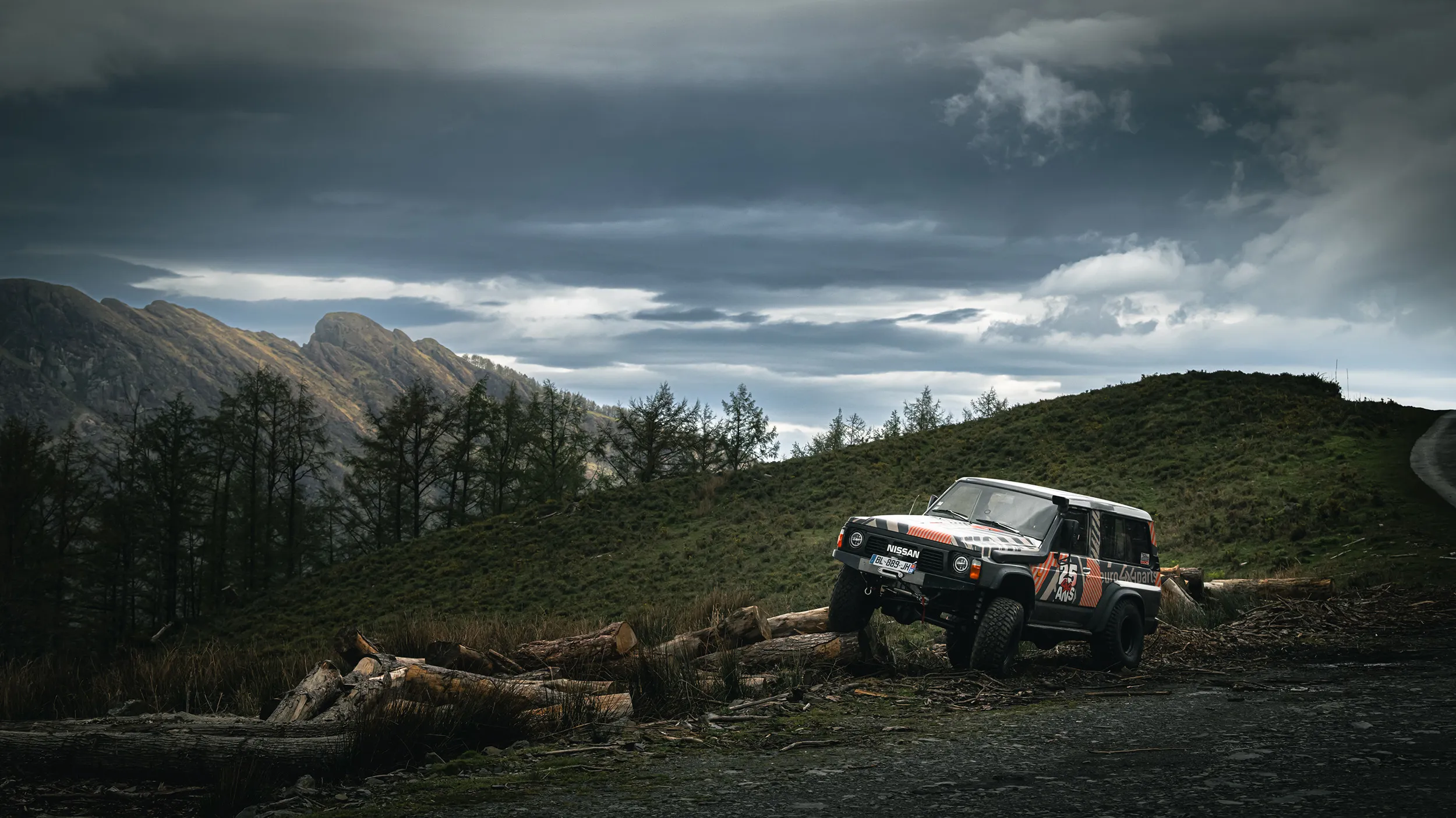 Nissan Patrol en franchissement sur des troncs, sur un versant de montagne