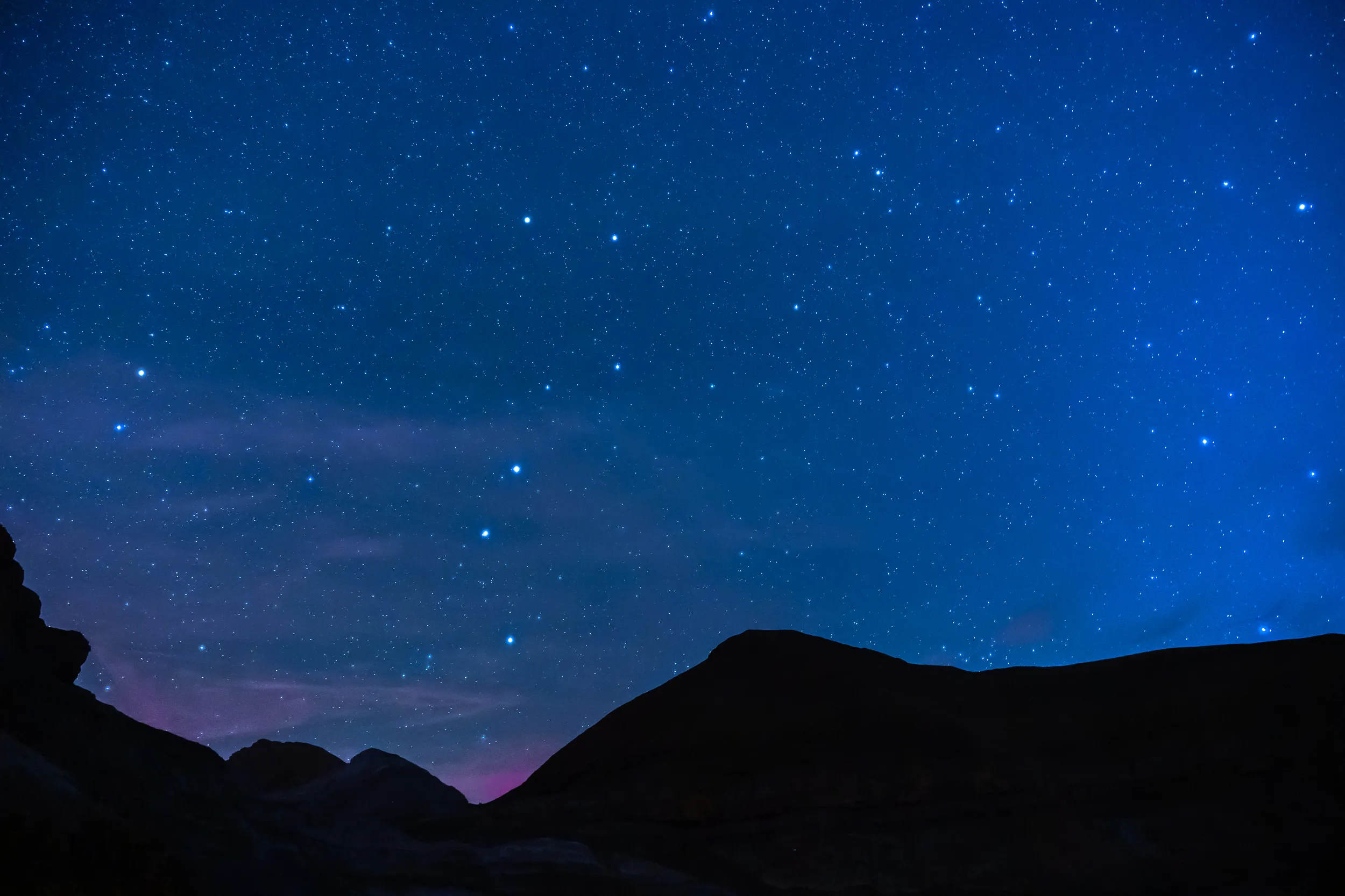 Un ciel d'un bleu profond semé d'étoiles au-dessus des crêtes sombres d'Ordesa