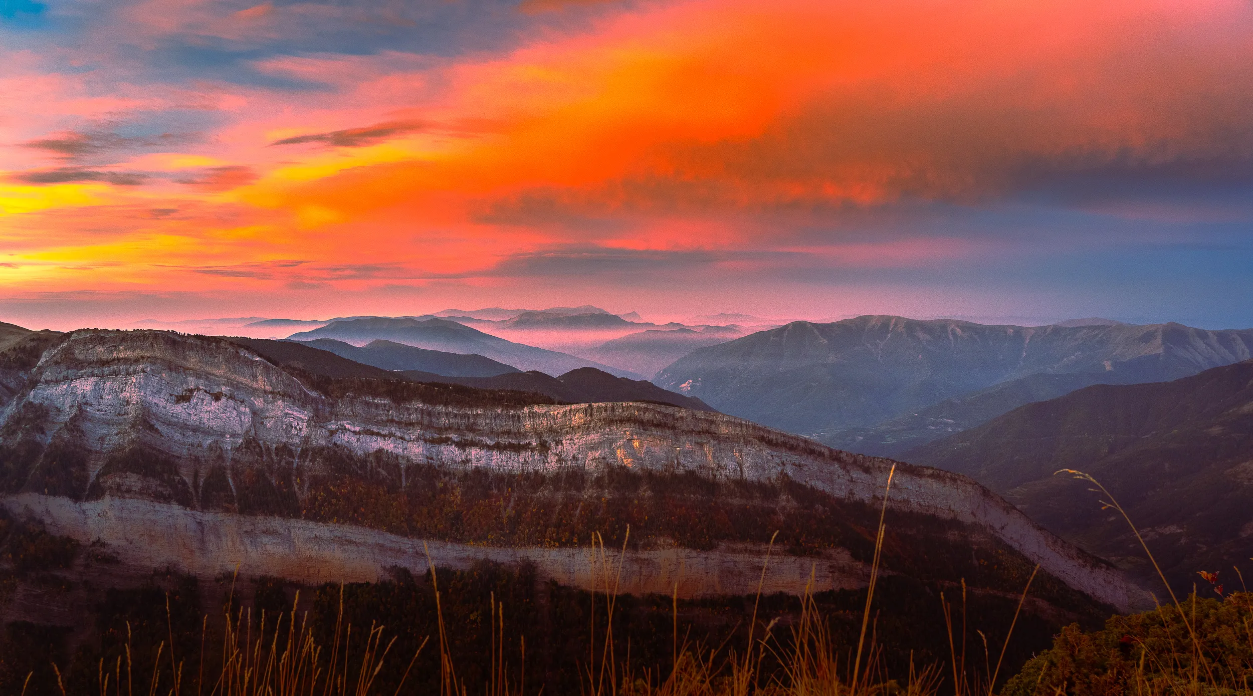 Panorama du canyon d'Ordesa sous un ciel orange et rose au lever du soleil