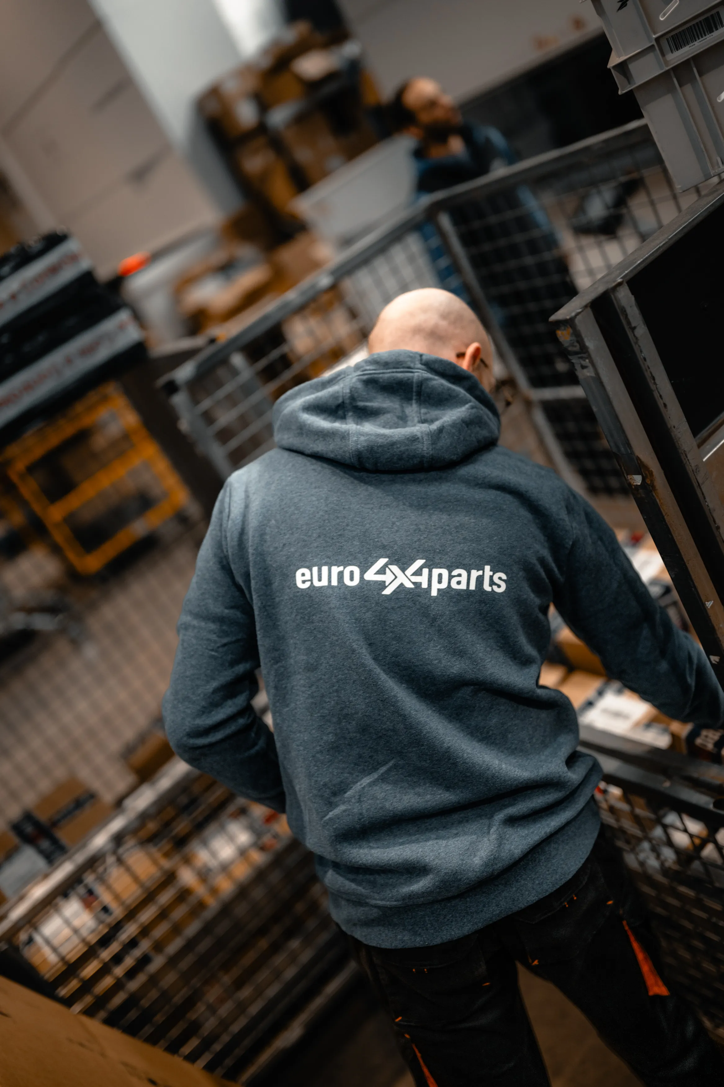 Préparateur en sweat Euro4x4Parts entre les chariots de l'entrepôt