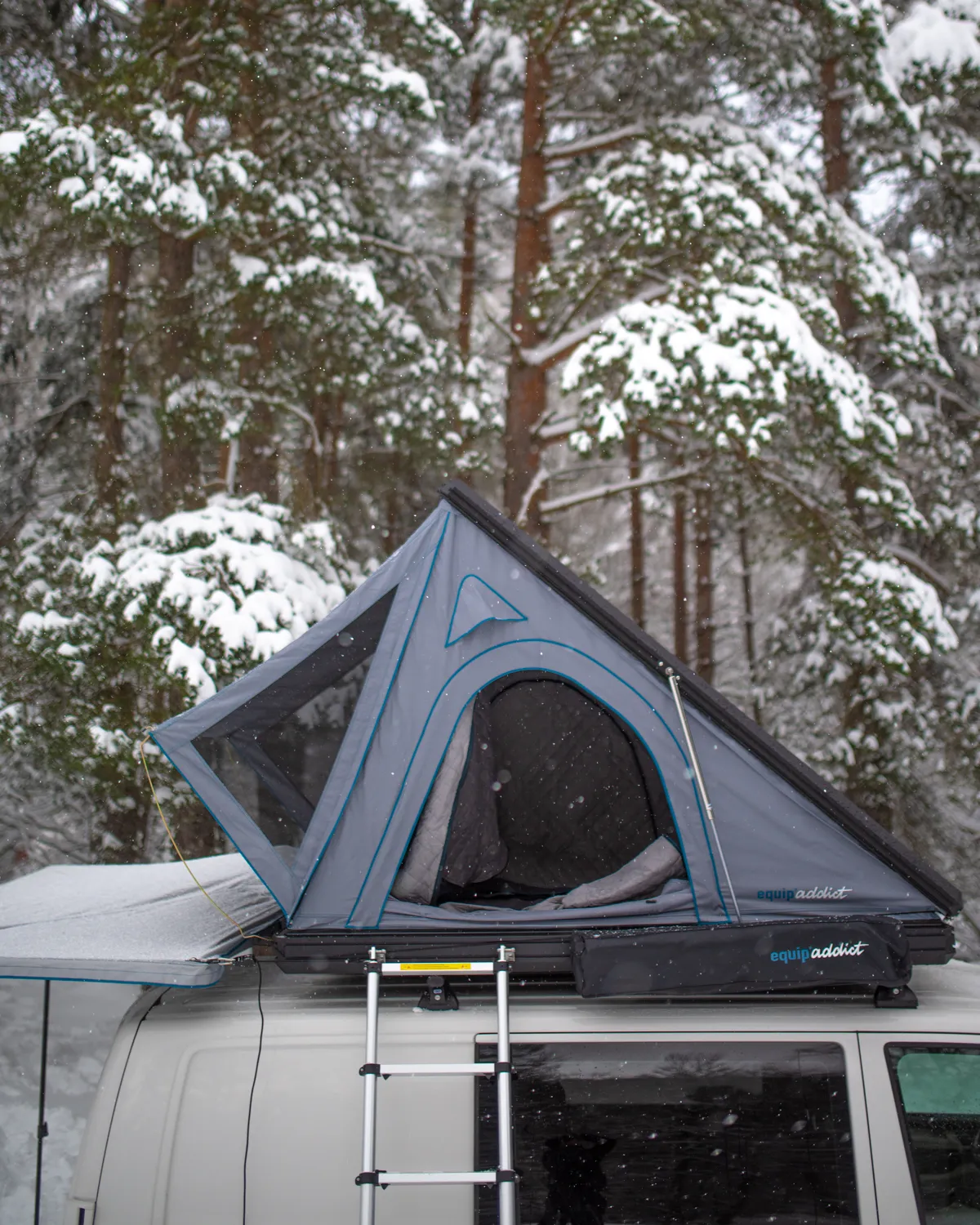 Tente de toit Equip'Addict dépliée sur un van, dans une forêt enneigée